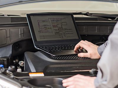 A laptop in a car's engine bay