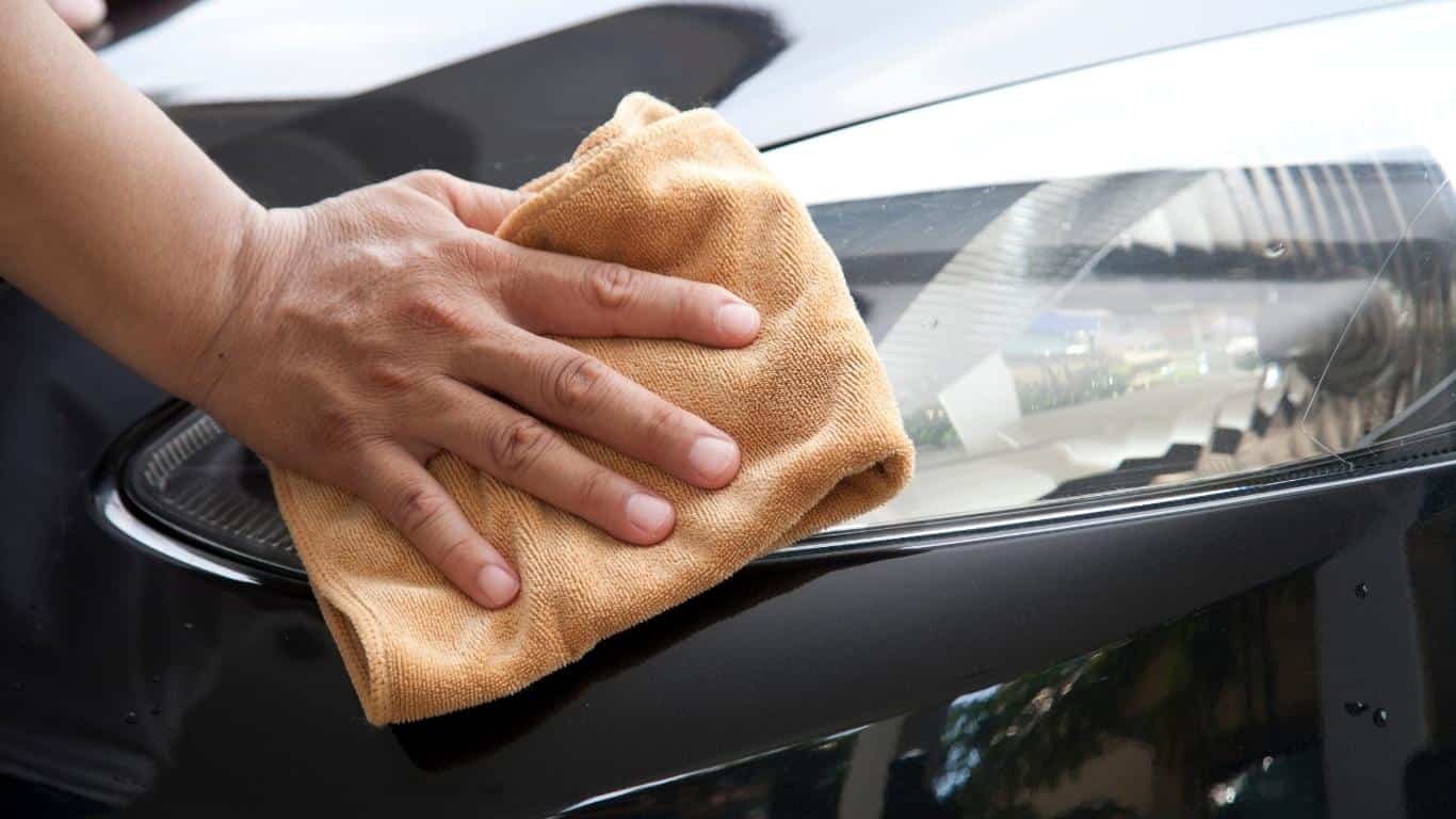 Microfiber towel being used to wipe headlights