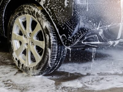 Black car and parts of ground covered in soap